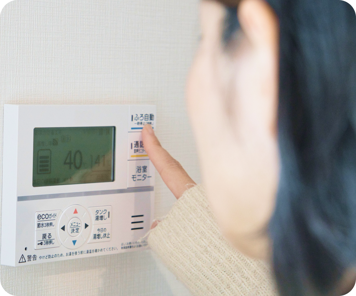 給湯器を操作する女性
